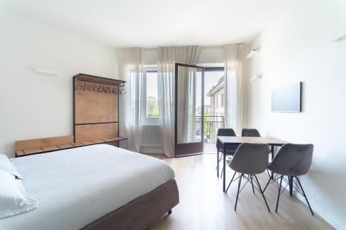 1 dormitorio con 1 cama, mesa y sillas en RGA Bergamo House, en Bérgamo