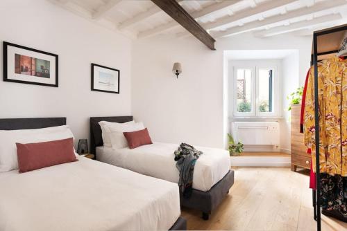a bedroom with two beds and a window at Idyllia - Cozy central retreat in Trastevere in Rome