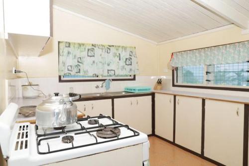 uma cozinha com um fogão e uma chaleira. em Gizo Lodge em Gizo