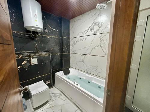 y baño con aseo y bañera. en Riviera Resort By Live Inn Rishikesh, en Bijni