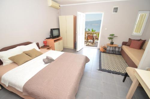 a bedroom with a bed and a living room with a couch at Porto Lastva Apartments in Tivat