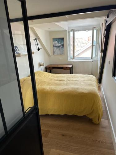 une chambre avec un lit jaune et une fenêtre dans l'établissement Superbe appartement plein centre de Biarritz, à Biarritz