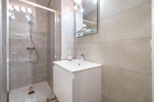 a white bathroom with a sink and a shower at Spacieux 3 pieces a 5 min des plages a pieds in Antibes