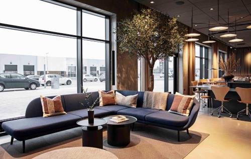 un soggiorno con divano blu e tavolo di Zleep Hotel Horsens a Horsens