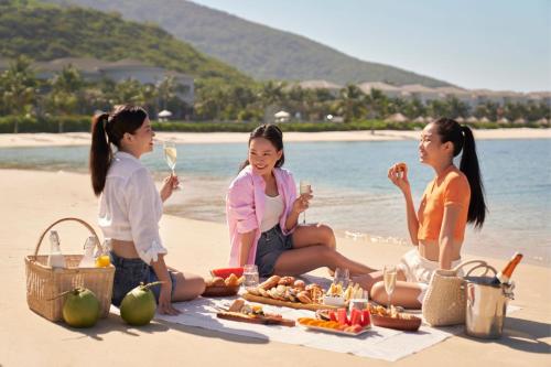 three women sitting on the beach eating food and drinking wine at Nha Trang Marriott Resort & Spa, Hon Tre Island in Nha Trang