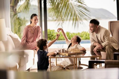 a family playing chess in a living room at Nha Trang Marriott Resort & Spa, Hon Tre Island in Nha Trang