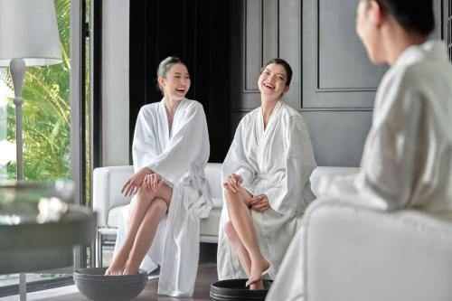 two women in white robes sitting on a couch at Nha Trang Marriott Resort & Spa, Hon Tre Island in Nha Trang