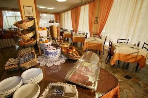 uma sala de jantar com uma mesa com pratos e pratos em Hotel Mamy em Rimini