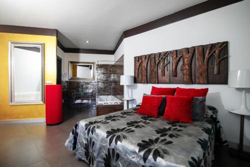 a bedroom with a large bed with red pillows at Hotel ACG in Los Villares