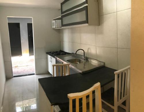 a small kitchen with a sink and a stove at Apartamento ao lado do beto carreiro in Penha