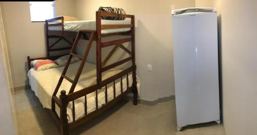 two bunk beds in a room with a refrigerator at Apartamento ao lado do beto carreiro in Penha
