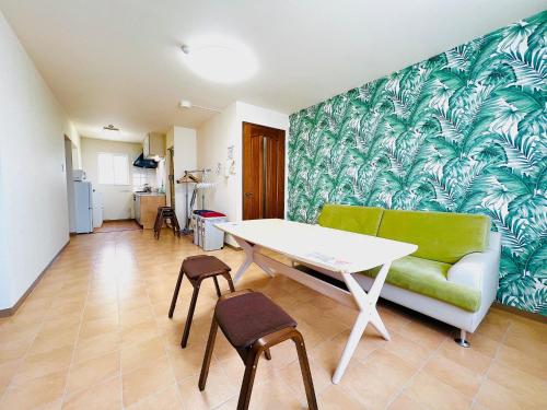 a living room with a table and a green couch at Hakodate Stoke Hills in Hakodate