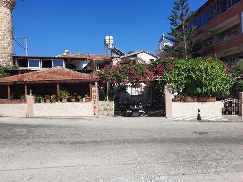 a building with potted plants on the side of a street at Arsuz Yunus Otel Bungalow in Arsuz