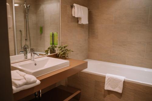 a bathroom with a sink and a bath tub at Hotel Auszeit St Lambrecht in Sankt Lambrecht