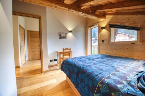 a bedroom with a bed in a room with wooden walls at Appartement Chez Francois in Morillon