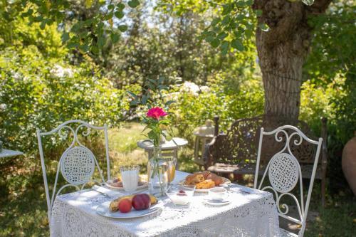 a table with a plate of food and a vase with a rose at Locanda Antico Casale Cesenatico in Cesenatico