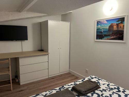 a bedroom with a bed and a desk and a tv at Appartement T3 indépendant in La Garde