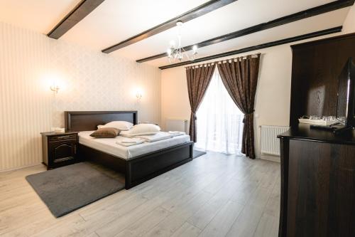 - une chambre avec un lit et une grande fenêtre dans l'établissement Pensiunea Poiana Avrigului, à Avrig