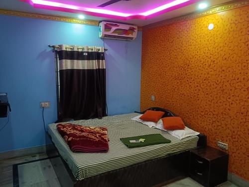 a bedroom with a bed with a purple light on it at Hotel Air View in kolkata