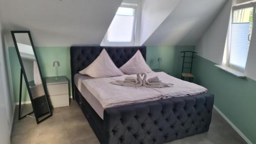 un letto con testiera blu trapuntata in una camera da letto di Fewo 3 a Deidesheim
