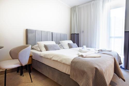 a bedroom with a large bed and a chair at Holimo Hotel in Stronie Śląskie