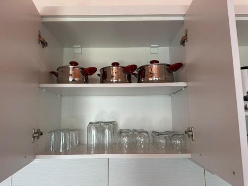 a kitchen with pots and glasses on a shelf at View13 in İskele