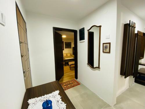 a hallway leading to a living room with a mirror at Vintage Apartment in Skopje