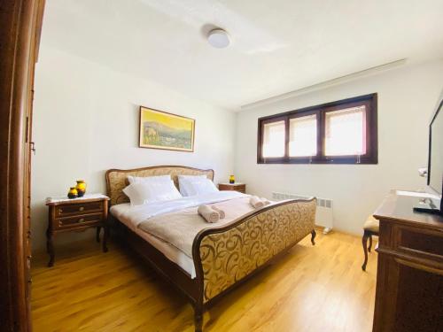 a bedroom with a large bed with a wooden floor at Vintage Apartment in Skopje