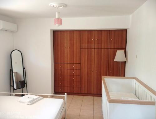 1 dormitorio con armario grande de madera y bañera en Geralis Lodge, en Chalkida