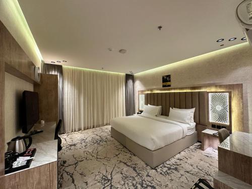 a hotel room with a bed and a television at حياة تاون 3 in Umm Lajj