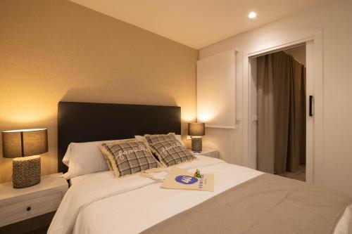 a bedroom with a large white bed with two lamps at Dorm4You Centro in Valencia