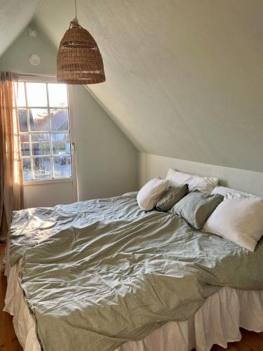 een slaapkamer met een groot bed met kussens erop bij Ryttaretorpet in Vellinge