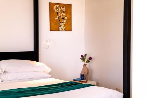 a bedroom with a bed and a vase of flowers at Luna Minoica Suites and Apartments in Montallegro