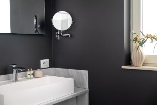 a bathroom with a white sink and a mirror at Luna Minoica Suites and Apartments in Montallegro