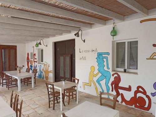 a dining room with a mural on the wall at La casa degli artisti in Ostuni
