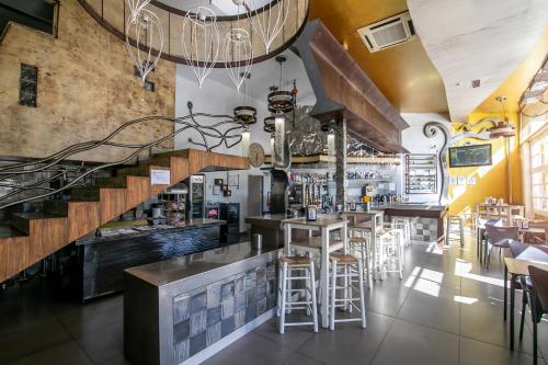 a bar with stools and a staircase in a restaurant at Hotel ACG in Los Villares