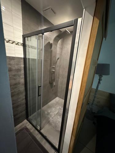 une douche avec une porte vitrée dans une salle de bain dans l'établissement Maison du pêcheur, à Marseille