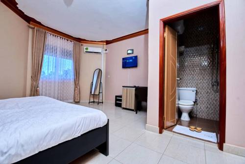una camera con letto e un bagno con servizi igienici di PB & J Guest House Entebbe a Entebbe