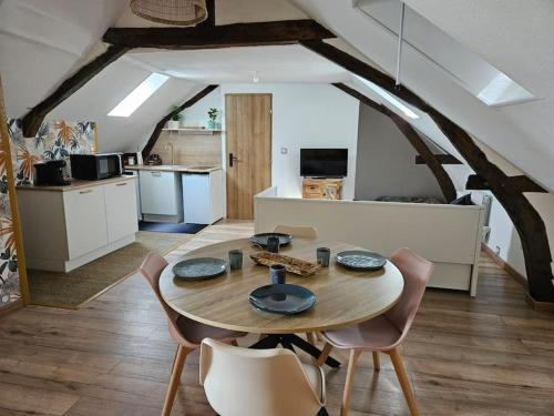 eine Küche und ein Esszimmer mit einem Tisch und Stühlen in der Unterkunft RÃªve de Loire in La Daguenière