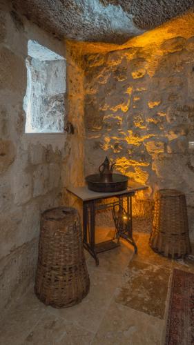 a stone room with a table and two stools at Theodora Village House in Urgup