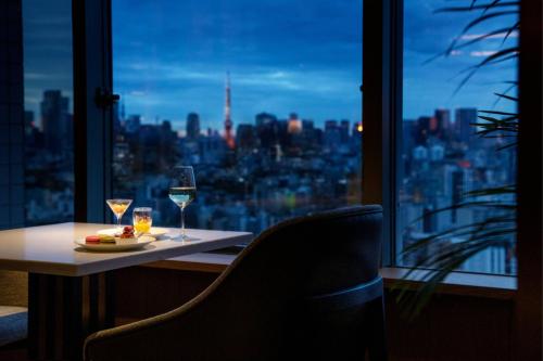 a table with two glasses of wine in front of a window at The Westin Tokyo in Tokyo