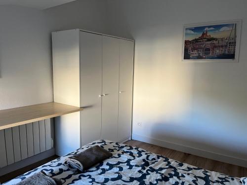 a bedroom with a white cabinet and a bed at Appartement T3 indépendant in La Garde