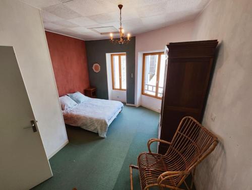 a bedroom with a bed and a chair in it at Le refuge des tanneurs in Tannay