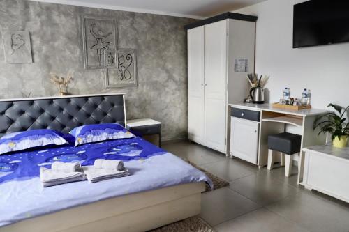 a bedroom with a bed with blue sheets and a desk at Cazare MOLDI - regim hotelier in Câmpulung Moldovenesc