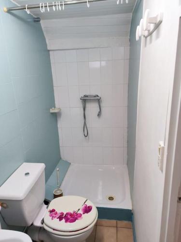 La salle de bains est pourvue de toilettes avec des fleurs sur le siège. dans l'établissement Le refuge des tanneurs, à Tannay