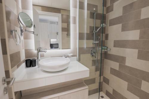 a bathroom with a white sink and a mirror at Cosy Studio at Palm Jumeirah in Dubai