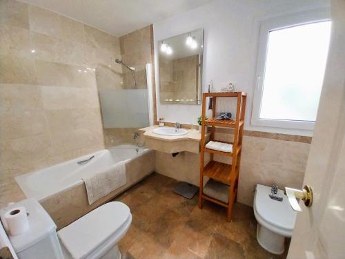 uma casa de banho com uma banheira, um WC e um lavatório. em Seaview Puerta del Mar first line beach em Sitio de Calahonda