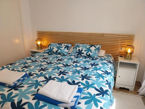 a bedroom with a blue and white bed with pillows at Seaview Puerta del Mar first line beach in Sitio de Calahonda