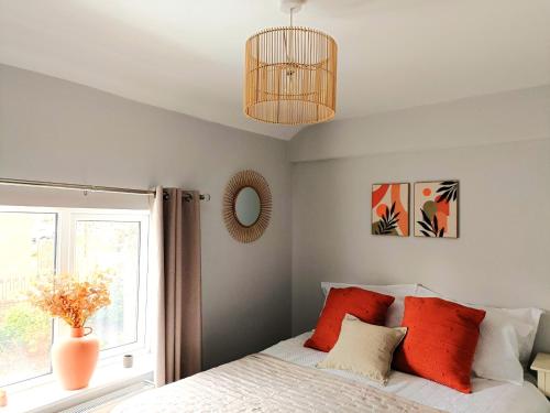 a bedroom with a bed with red pillows and a window at Charming Terrace Home in Whitchurch in Whitchurch