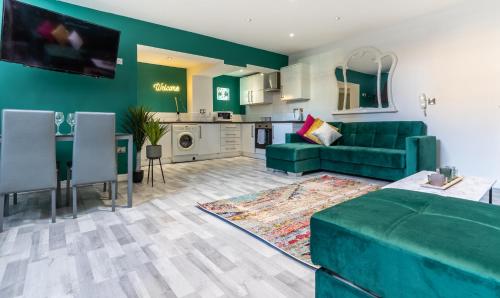 a living room with a green couch and a kitchen at Hackins Hey spacious Liverpool stays central city in Liverpool